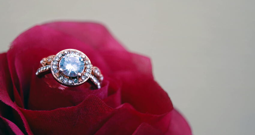 Ein Diamantring auf einer Rosenblüte liegend.